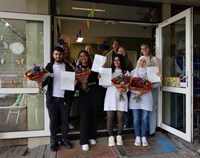 Groepsfoto van de personen die een certificaat en bos bloemen vast hebben