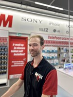 Rutger op de werkvloer bij MediaMarkt. Hij heeft bedrijfskleding aan.