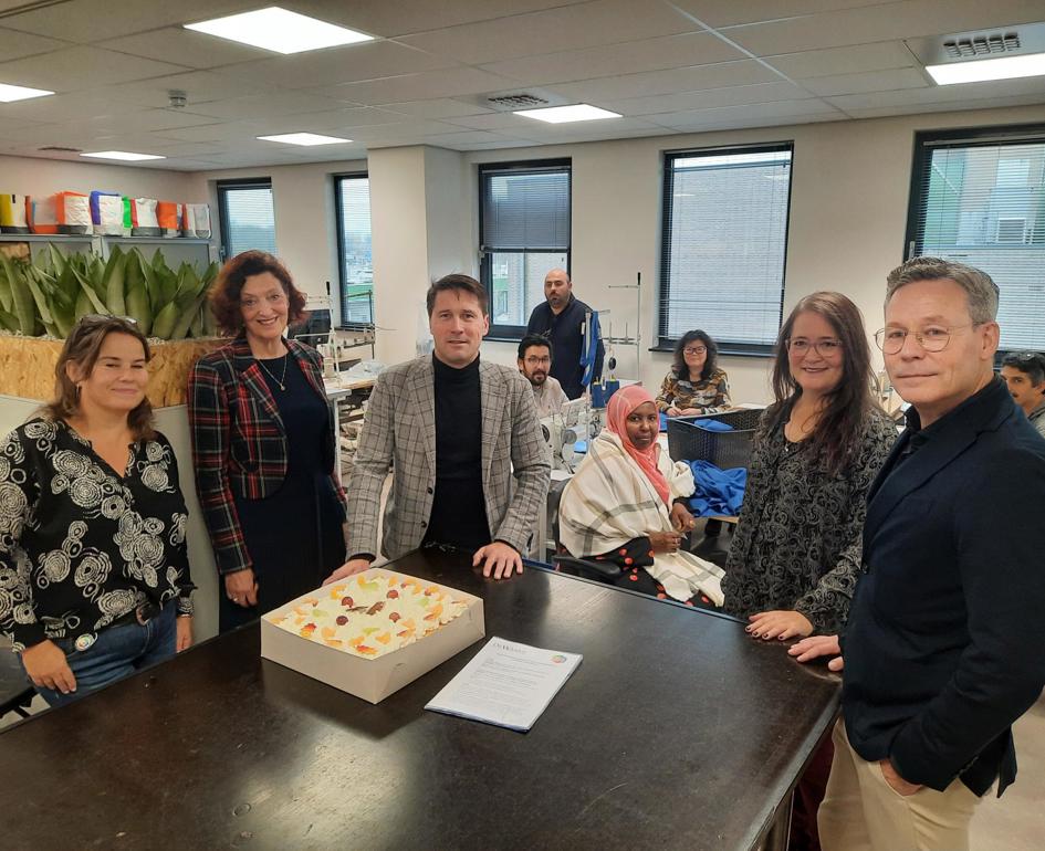 Foto: Taart ter ere van een mooi voorbeeld van publiek-private samenwerking. Vlnr: Carla Ruiter, Marjolijn Dölle (WerkSaam), Gert-Jan van ’t Spijker (De Waard Beroepskleding), Marita Schoonheijm (WerkSaam) en Matthieu de Waard (De Waard Beroepskleding)